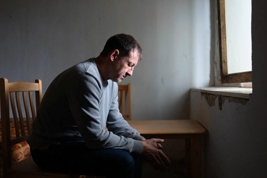 Мужчина сидит один в комнате